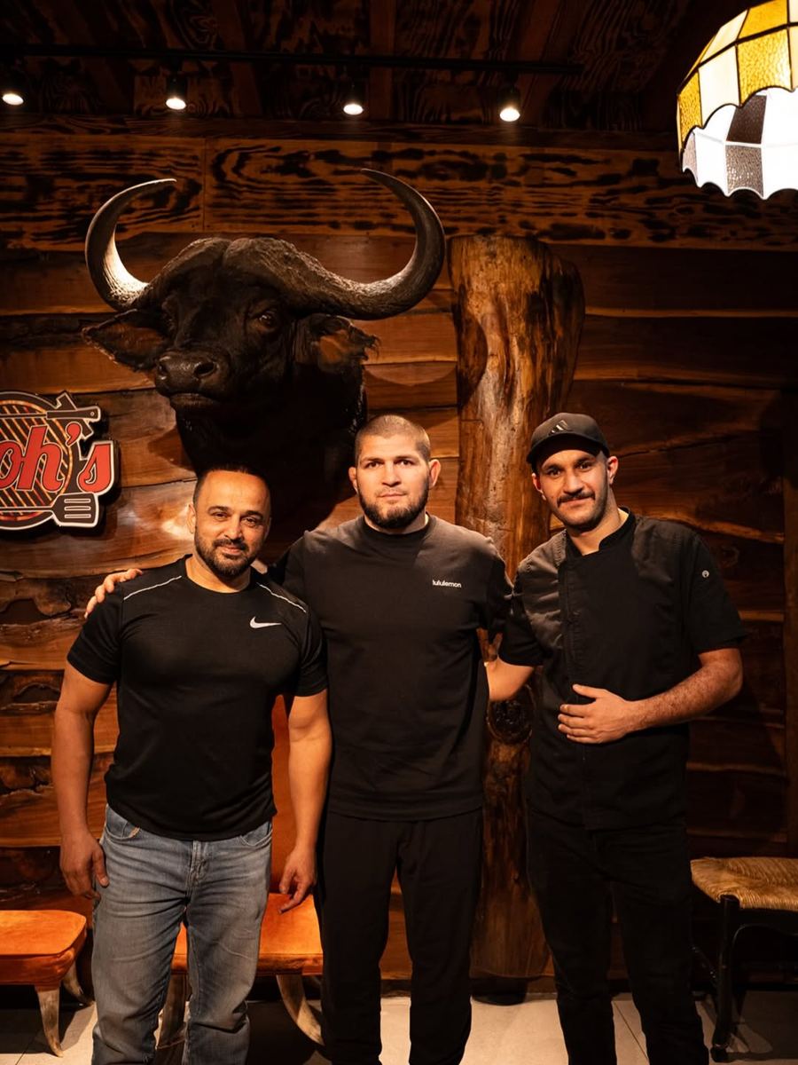 Rahim, Khabib Nurmagomedov and Chef Furqan under the buffalo head in the Rooh's dining room